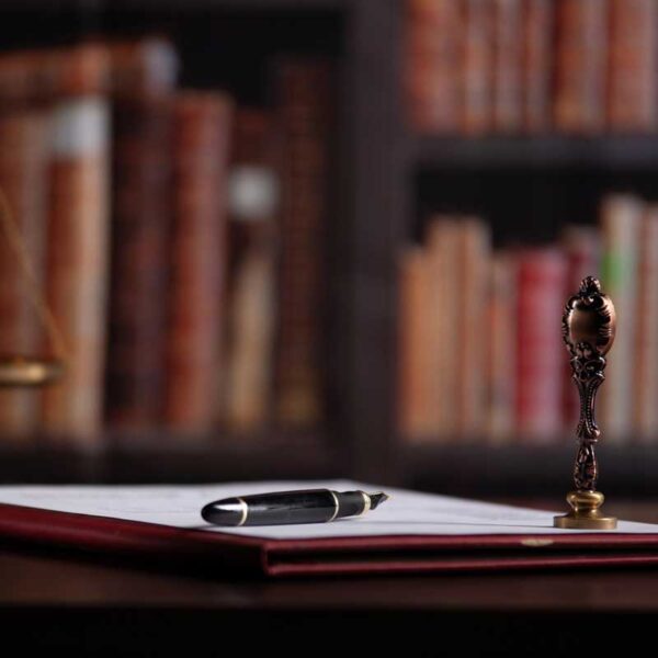 a pen rests on an estate plan next to a wax seal