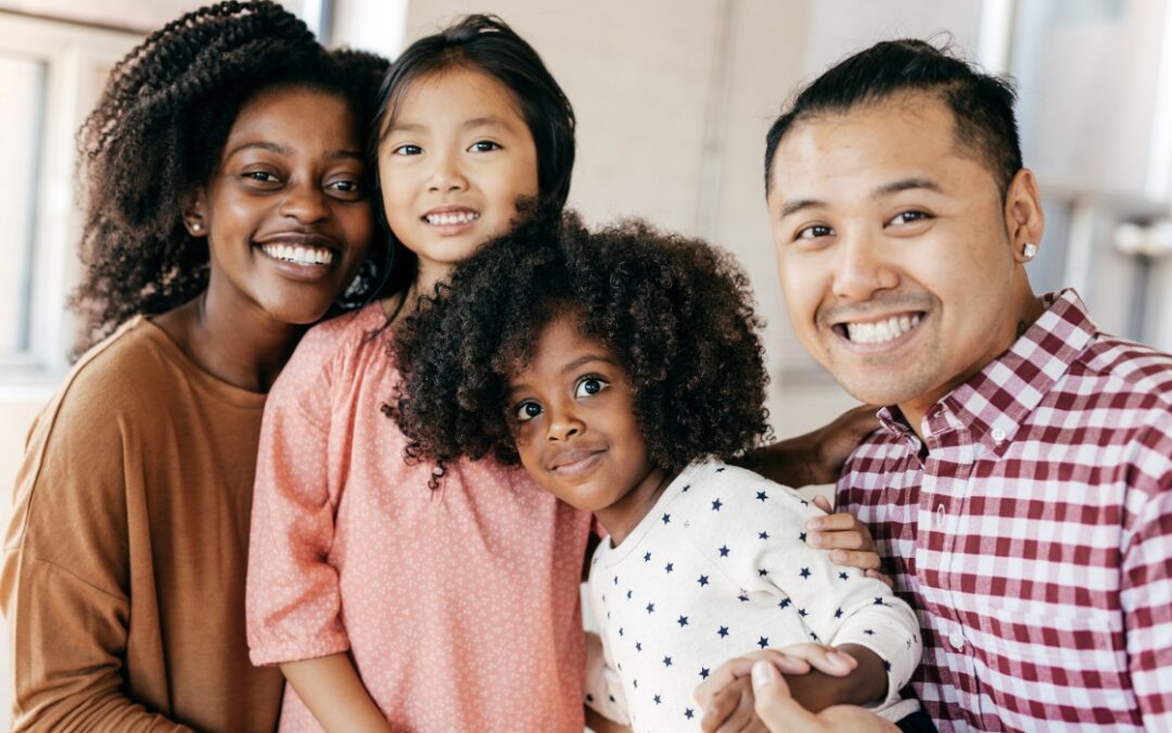 A blended family posing for a picture together, smiling brightly