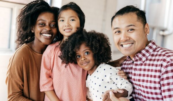 A blended family posing for a picture together, smiling brightly