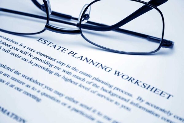 a pair of glasses lays upon an estate planning worksheet
